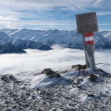 Dezember 2017  In den Tälern liegen die Wolken und ziehen sich wie weiße Bänder durch die Alpen. Von unten gesehen ein undurchdringliches Grau. Oft ist nur oben auf den Gipfeln eine herrliche Sicht. So war es auch auf dem Gipfel des Wildkogel in Neukirchen am Großvenediger. Während unserer Skiausfahrt am Jahreswechsel steige ich immer auf mindestens einen der umliegenden Gipfel. Vom Skigebiet sind es vergleichsweise wenige Höhenmeter und diese werden auch noch mit einer schönen Aussicht belohnt. Im Süden liegen die Hohen Tauern und nördlich der Wilde Kaiser. Wie schön öfters erwähnt, zieht es mich immer zum Gipfelkreuz. Auf dem Wildkogel gibt es außer dem Gipfelkreuz aber auch ein schönes altes Wegzeichen ...